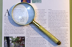 Open book with a magnifying glass laying on top
